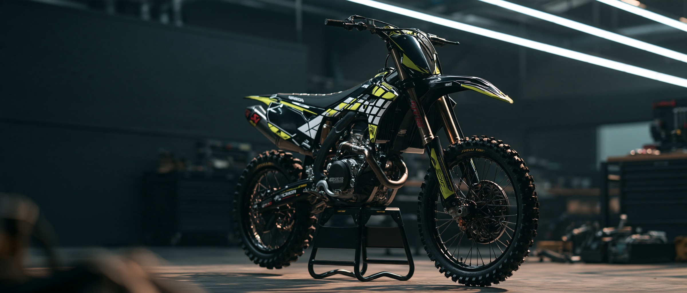 Custom motocross graphics kit in black and volt yellow — a precision-cut Apex Wrap Lab vinyl wrap on an enduro dirt bike in the workshop